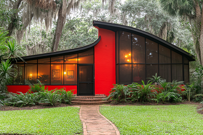 Modern Red House Surrounded by Lush Greenery